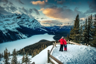 A couple in snowsuits looking out over a mountain