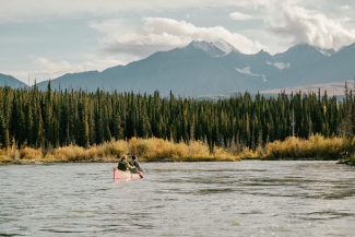 Two people canoeing with mountain view